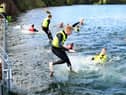 YFCU members jumping in to swim across to Splash NI’s inflatable water park