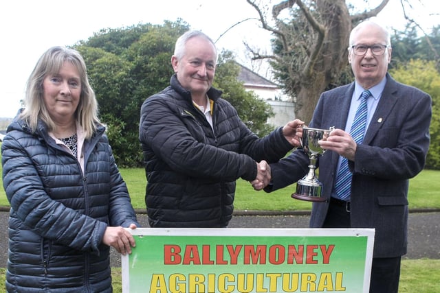 Brook Huey (2nd left), owner of Glynns Bar Ballymoney, pictured presenting a new cup to Show President James Morrison. The trophy will be presented to the Galloway Champion and looking on is Show Secretary, Anne McLaughlin.