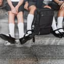 Group of international school students in school uniforms, sit on steps