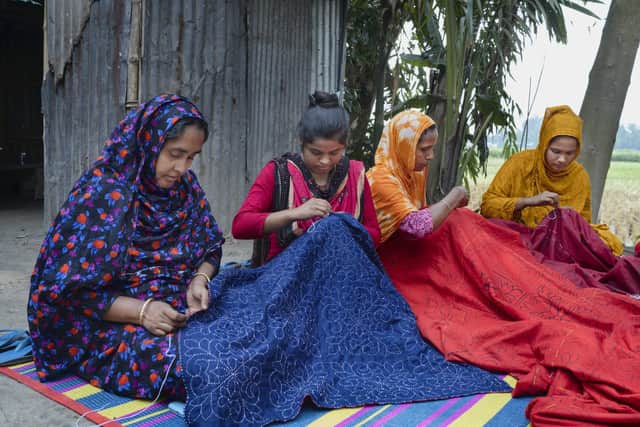 Kakoli Khatun (2nd from left) and other women supported by Christian Aid’s local partner are earning an income by keeping alive the tradition of nakshi kantha, the centuries-old Bengali art of quilt-making which involves embroidering old saris with thread. Credit: Fabeha Monir/Christian Aid