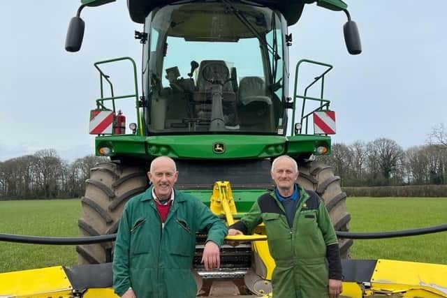 Brothers John and Jay Bromell in front of the 2017 JD 8400i forage harvester included in the sale. (Pic: Cheffins)