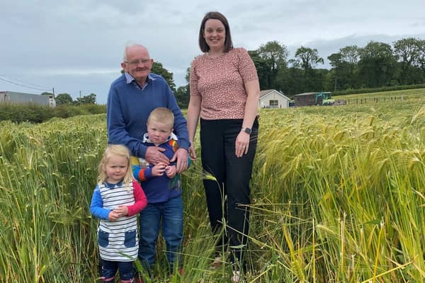 East Tyrone UFU group manager Stacey Cherry along with Wesley Davidson and his grandchildren Ben and Chloe in his award-winning field of winter barley.