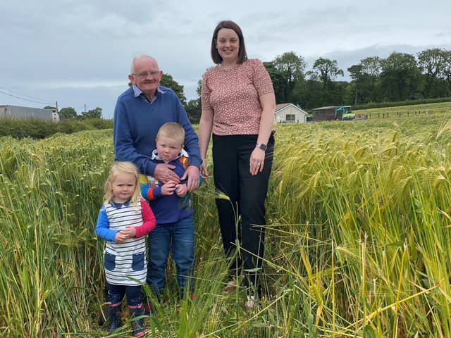East Tyrone UFU group manager Stacey Cherry along with Wesley Davidson and his grandchildren Ben and Chloe in his award-winning field of winter barley.