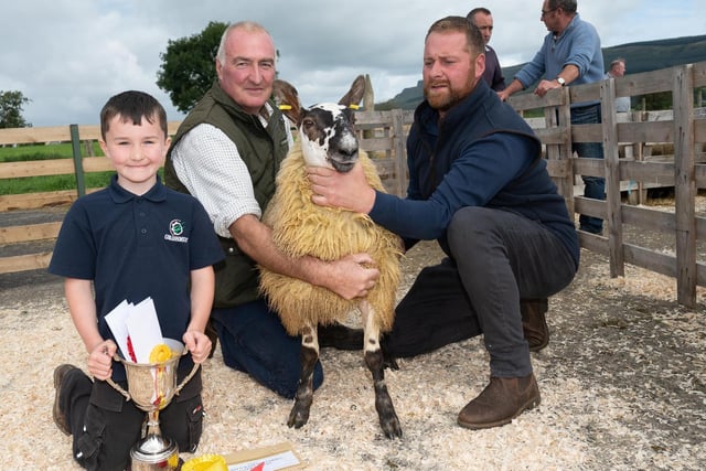 Arnold Douglas and Sam Douglas with the champion grey face and Alwyn McFarland, judge, at the Alexander Gourley open air sheep show and sale at Aghanloo on Tuesday morning. Photo Clive Wasson