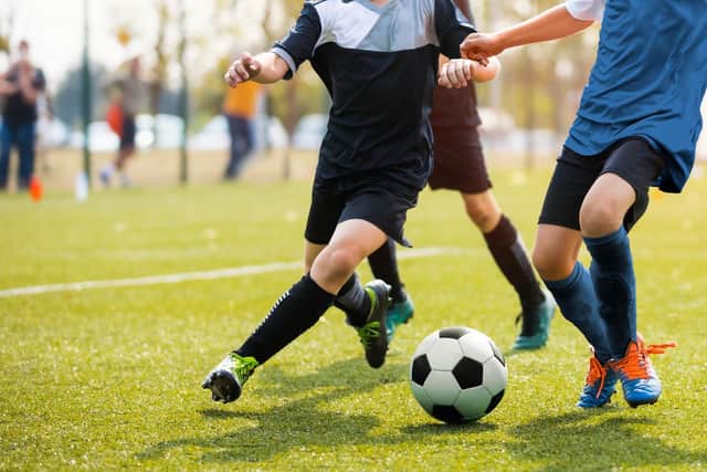 Legs of two young football players on a match.