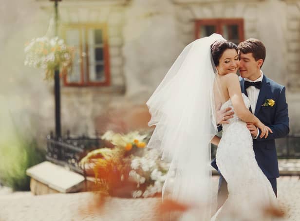 Groom holds bride's waist tenderly at a wedding in Spain