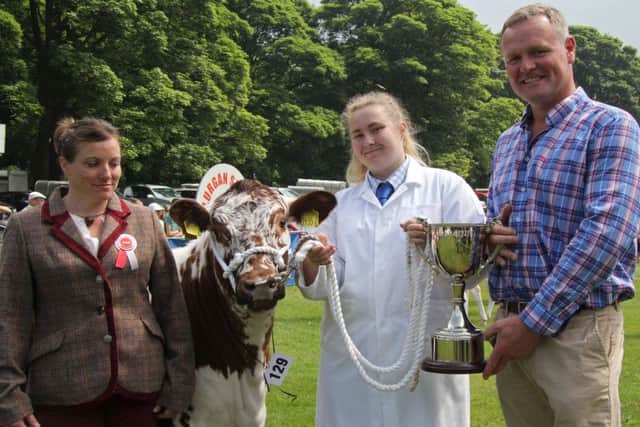 Kyle Savage presents the George Savage Memorial Cup to Rachel Armour, who exhibited the Irish Moiled champion Beechmount Jasmine at Lurgan Show. Looking on is judge Tamzin Mogg from Worcestershire. Picture: Julie Hazelton