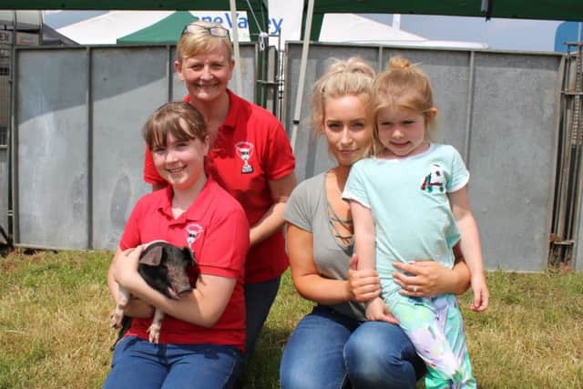 Eden McNally and her young daughter Aoibha, from Keady, congratulate Samara Radcliffe and her mother Sharon on winning the Pig Championship at Armagh Show 2018
