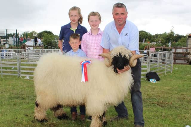 Richard Beattie, from Omagh, holds a Valais Blacknose ram with his son Richard plus daughters Rachael and Sarah