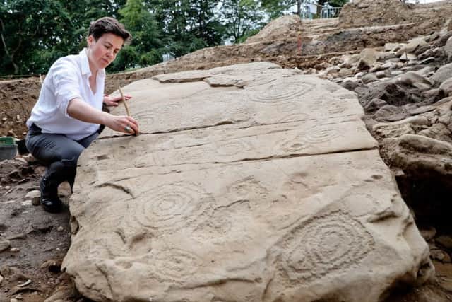 Dr ClÃodhna Nà Lionáin, Devenish's lead archaeologist is pictured with some of the pieces of unearthed Kerbstone from the recently discovered Megalithic passage tomb within the Brú na Bóinne World Heritage Site