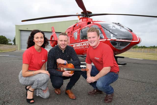 James Speers, YFCU president, and Kerry Anderson from Air Ambulance NI are pictured with Ritchie Remo, headline act for the presidents fundraising barn dance and barbecue for Air Ambulance NI