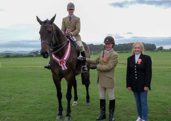 The Lagan Construction Supreme Hunter Championship winner Lesley Webb with The Marksman, Judge Kevin McGuiness and Show Director Joan Cunningham at Saintfield Horse Show