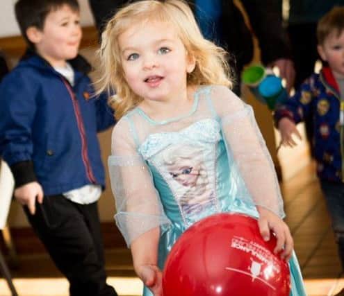 Dressed to impress and celebrating her 3rd birthday, Penny Lee enjoying playing with an Air Ambulance balloon.