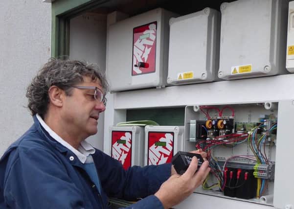 Tim Miller checks a fail-safe battery on a 400-pig place finishing building on a Midlands farm