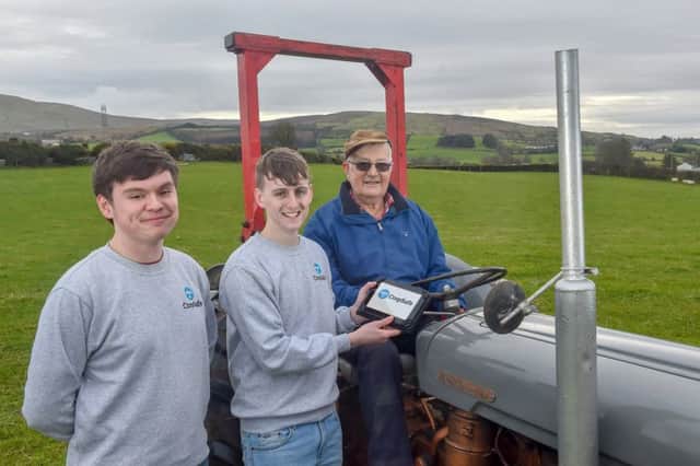 St. Mary's Grammar School pupils John McElhone and Micheal McLaughlin demonstrate their CropSafe app to Micheal's grandfather, Mickey Joe McGuigan, on his farm in Draperstown.