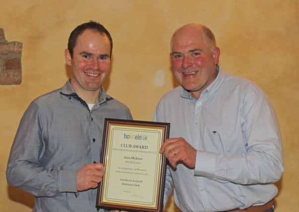 Outgoing chairman Jason Booth presents Holstein NI's Club Award to Bushmills breeder Iain McLean. Picture: Julie Hazelton