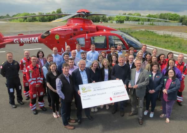 The UFU celebrating its £200,000 fundraising achievement and the Institute of Fundraising NI award at the Air Ambulance NI base in Lisburn.