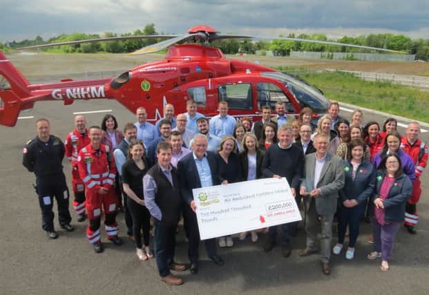 The UFU celebrating its £200,000 fundraising achievement and the Institute of Fundraising NI award at the Air Ambulance NI base in Lisburn.
