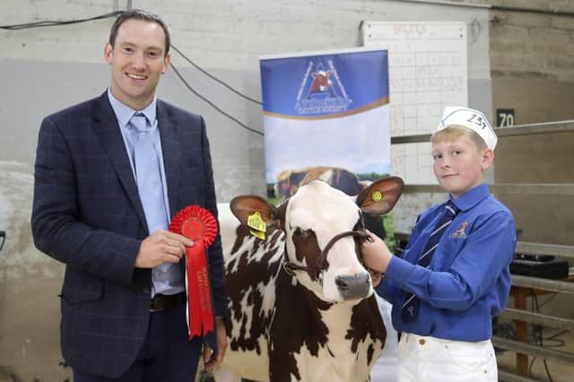 Champion Ayrshire was the Robert and Caroline McConnells Beechmount Marie Girl 23 handled by Camerson Carson. adding his congratulations is judge Iwan Thomas. Picture: Jane Steel