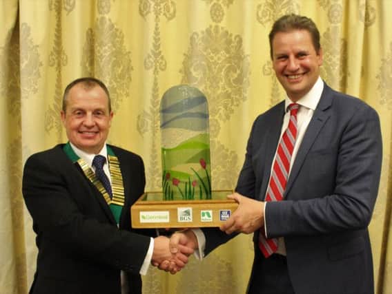 BGS president Richard Simpson (left) presents John Martin with the BGS Grassland Farmer of the Year Award trophy