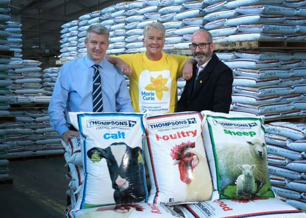 Thompsons' Sales Director Gordon Donaldson celebrates the launch of 'Yellow November' in the York Road bagged feed warehouse, with Marie Curies Anne Hannon and Conor OKane