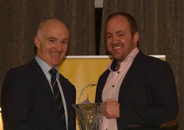 Connor Mulholland receives the Fedney House trophy from Finbar O'Brien, Chairman