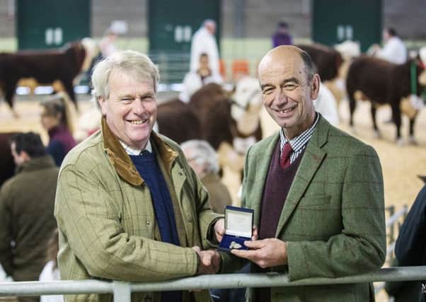 Mark Roberts (right) is presented the president's badge by out-going president Jonathan Moorhouse at the Christmas calf show, Shrewsbury