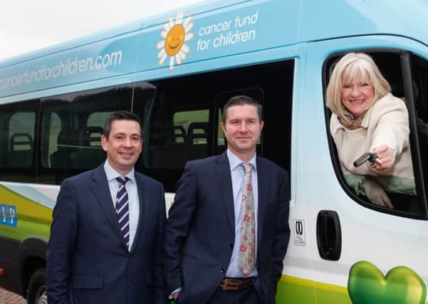 A delighted Gillian Creevy, chief executive NI Cancer Fund for Children, accepts the keys to a specially adapted minibus from Mike Crane, managing director LV, Liverpool Victoria, insurance broker division. This year the annual LV minibus for charity came to NI thanks to the efforts of Paul Williamson, left, and colleagues at Crumlin, Co Antrim farm insurance brokers CIP. The minibus will be based at the charitys innovative respite care facility for cancer patients and their families overlooking the Mournes near Newcastle.  Photograph: Columba O'Hare