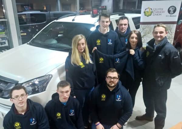 Senior Group Manager, Gyles Dawson presents members of Crumlin YFC with their new hooded jackets.