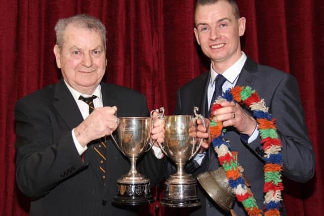 Chairman Richard Rodgers congratulates Wesley Abraham, Irvinestown, who collected an array of trophies at the club's annual dinner.