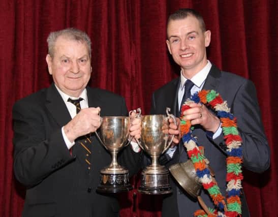 Chairman Richard Rodgers congratulates Wesley Abraham, Irvinestown, who collected an array of trophies at the club's annual dinner.