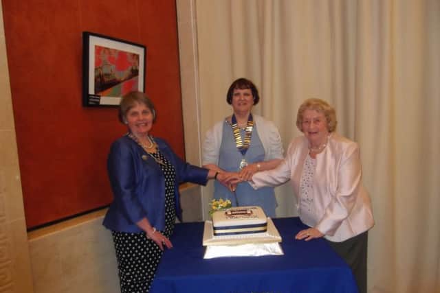 Federation Chairman, Elizabeth Warden; President of Ballywalter WI, Pamela Brown; Lorna Walker, longest serving member of Ballywalter WI cutting the Anniversary Cake