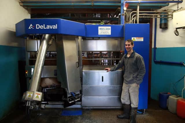 Marcus Grey with some of the DeLaval VMS milking robots which are improving efficiency on his farm at Killadeas.