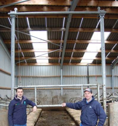 Teemore Engineering's Fergal Quinn (left) and Banbridge milk producer George Mitchell standing in front a new guillotine gate