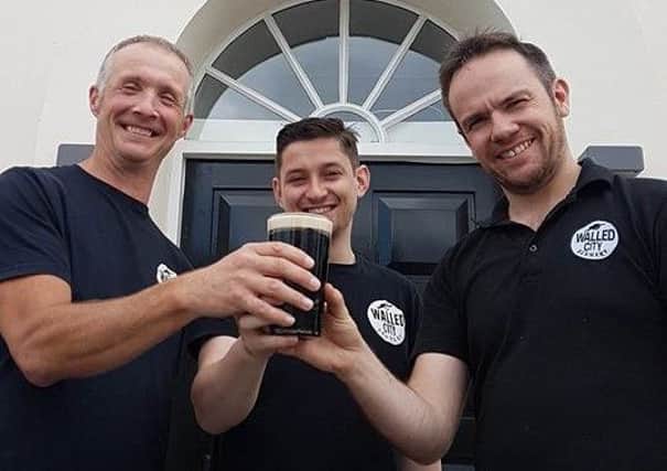 James Huey (right), owner of Walled City Brewery, celebrating their new Derry Milk stout with staff members Andrew Rough and Cathal Barr.