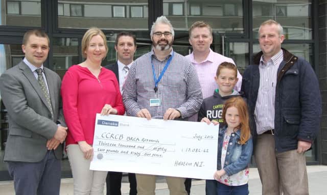 The Centre for Cancer Research and Cell Biology at Queen's University has received a cheque for over Â£13,000 from Holstein NI. Dr Kienan Savage, centre, is pictured with Derek Nelson, Ecosyl; hosts Ivor and Cecilia Broomfield; chairman John Berry; and Drumbo herd owners Gary, Callum and Zara Reid, Drumbo, who purchased the top priced calf at the charity auction. Picture: Julie Hazelton