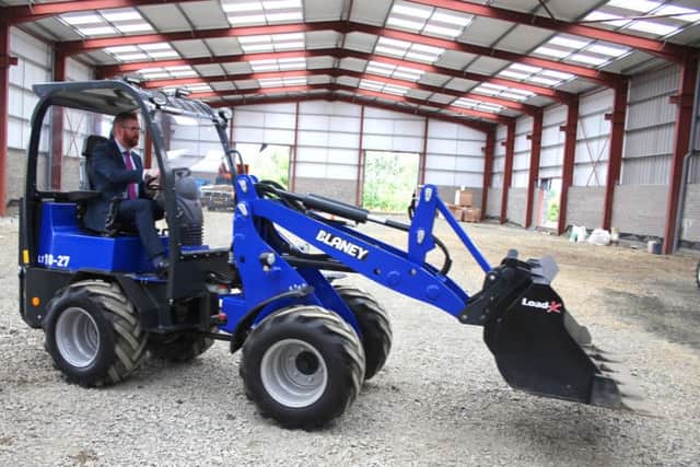 Economic Minister Simon Hamilton test drives new Blaney loader concept at Blaney Agri Solutions
