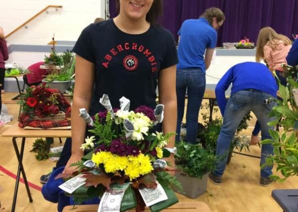 A member of Dungiven YFC with her floral art display made with this years theme Rich Pickings