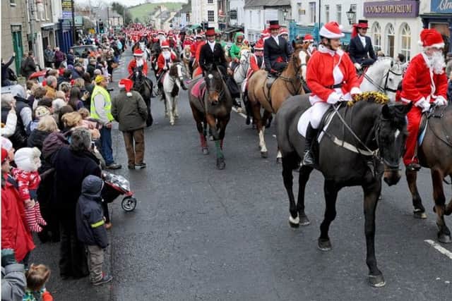 Event organiser Joan Cunningham leads the santas into Saintfield's Main Street