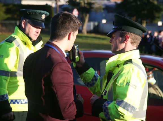 Constable Henry and Constable Crawford breath test a pupil as part of the road traffic collision demonstration.