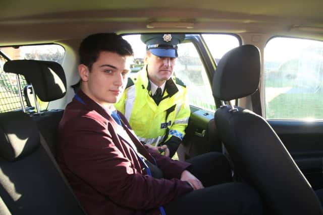 A pupil is arrested by Constable Mark Crawford during the road traffic collision demonstration.