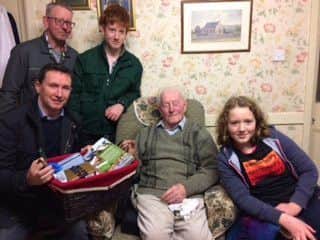 Robert McIlroy receiving a hamper from Terence Fox, South Tyrone UFU Group Chairman.  Robert son William McIlroy and grandchildren Samuel and Eva McIlroy are also in  the photo.