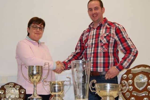 Allen McFadden being congratulated by new chairwoman Josephine Wray with some of his awards for the year