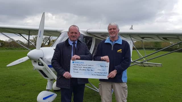 Group Manager Lawson Burnett presenting a donation to Raphael OCarroll of Kernan Aviation, fundraiser for The Brain Tumour Charity and Marie Curie Cancer Care