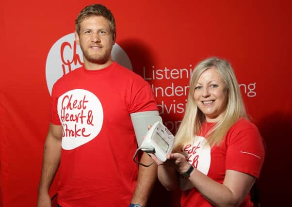 L-R: Chris Henry, Ulster Rugby Player, and Gillian Parker, Communications and Marketing Manager at NICHS. Ulster Rugby Star Chris Henry was one of the many people who had his blood pressure checked by Northern Ireland Chest Heart and Stroke at the Balmoral Show.
