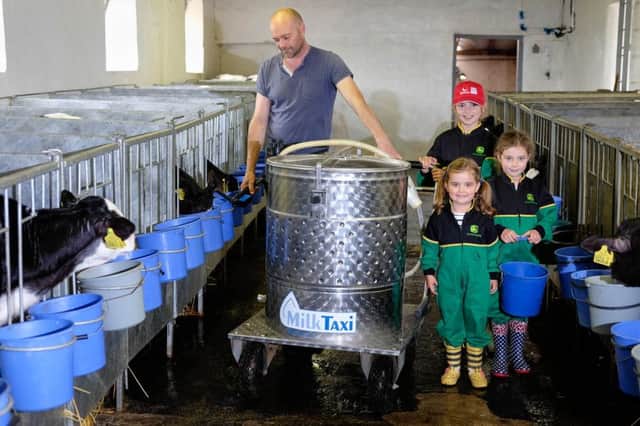 Young stock manager Julian Spratt gets some help feeding the newly born calves from Hannah, Abie and Emma Jackson  on the Jackson farm at Bangor. Photograph: Columba O'Hare