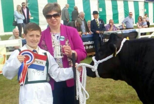 Kile Diamond receives his Champions rosette, certificate and tankard from the judge.