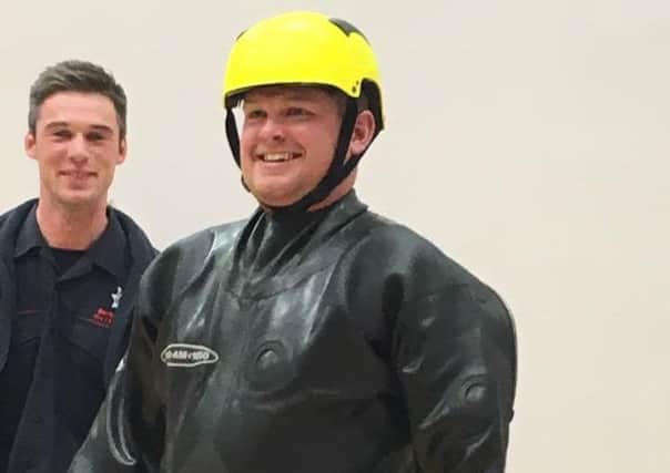 Simon Agnew, club vice president, tries the NIFRS specialist gear for rescuing animals from a slurry tank